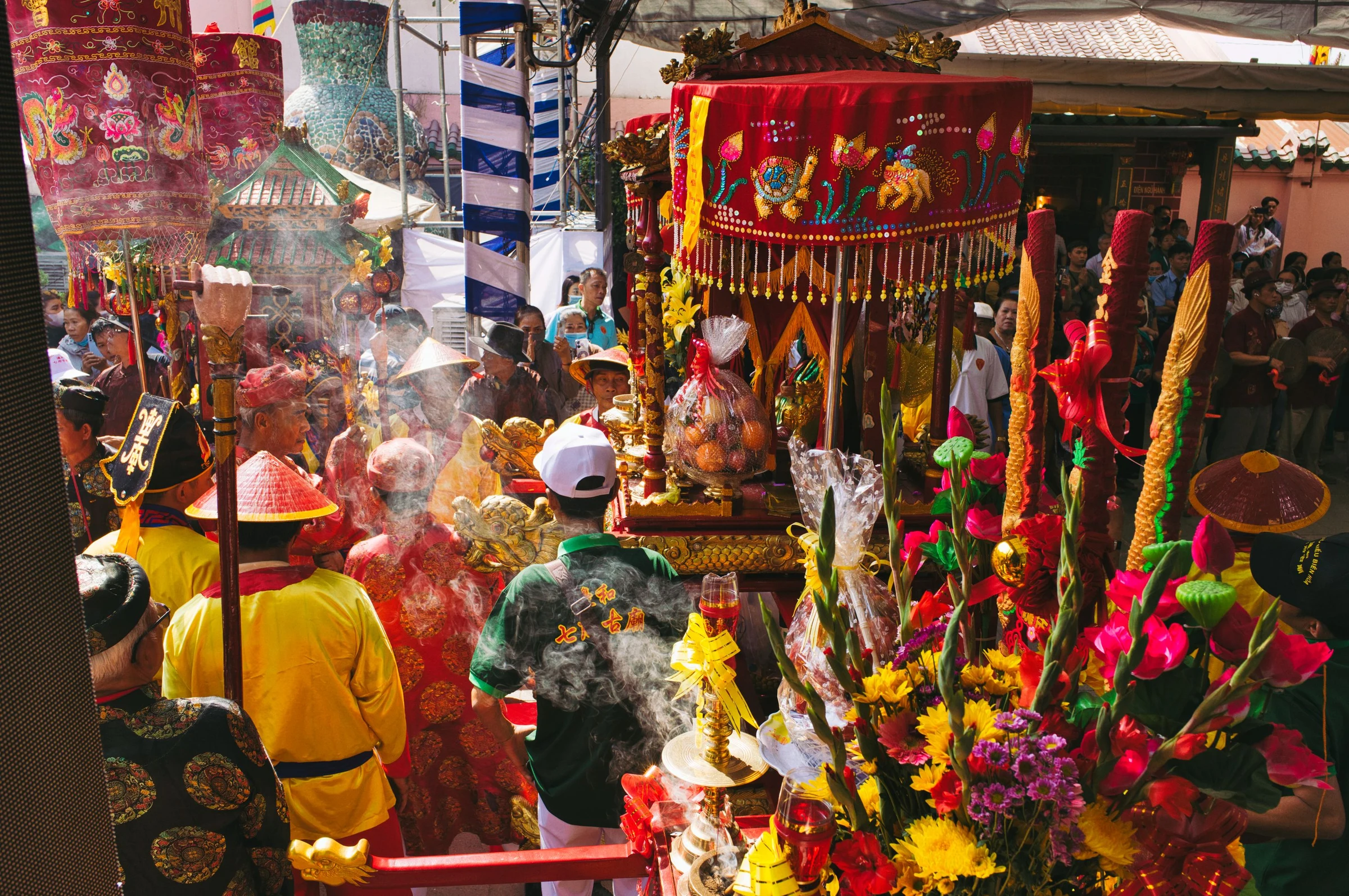 People gathered around colourful ceremonial displays at an Asian cultural festival