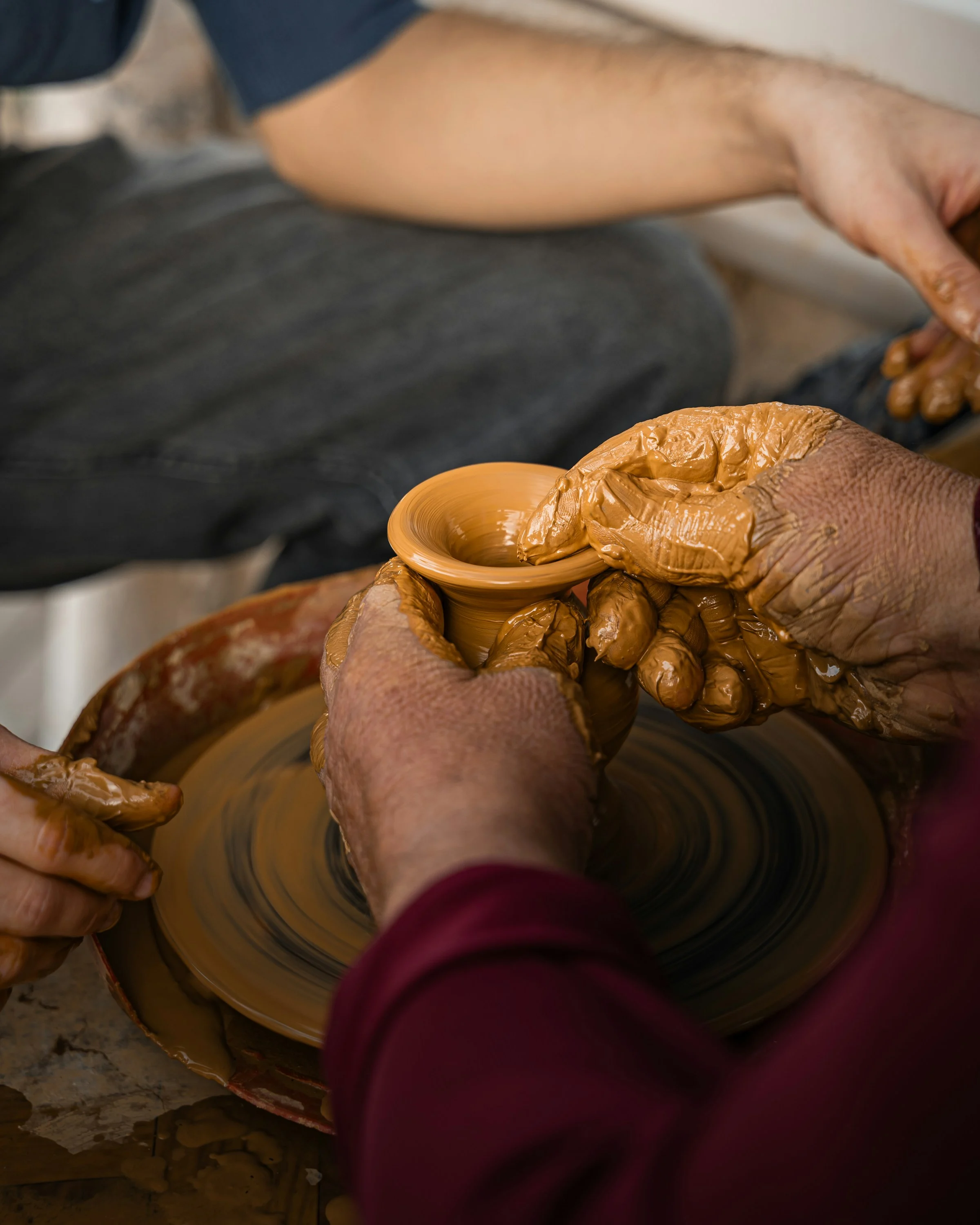 A potter shaping a clay vessel