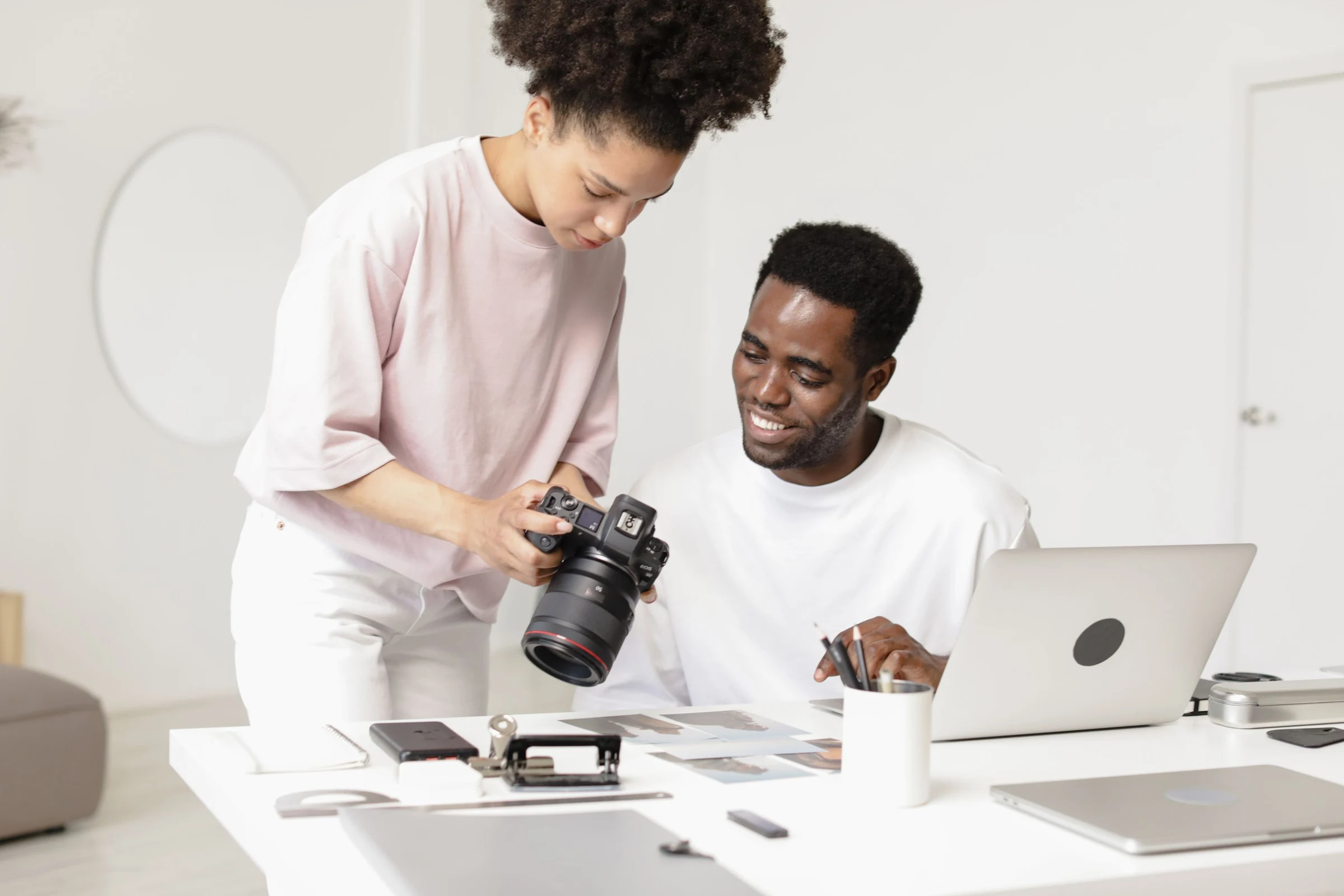 Two photographers reviewing a camera and images together in a bright studio