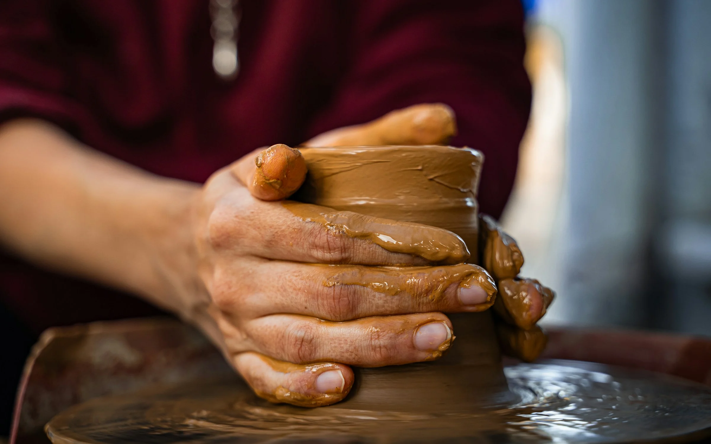 Artisan hands shaping clay on a potter's wheel