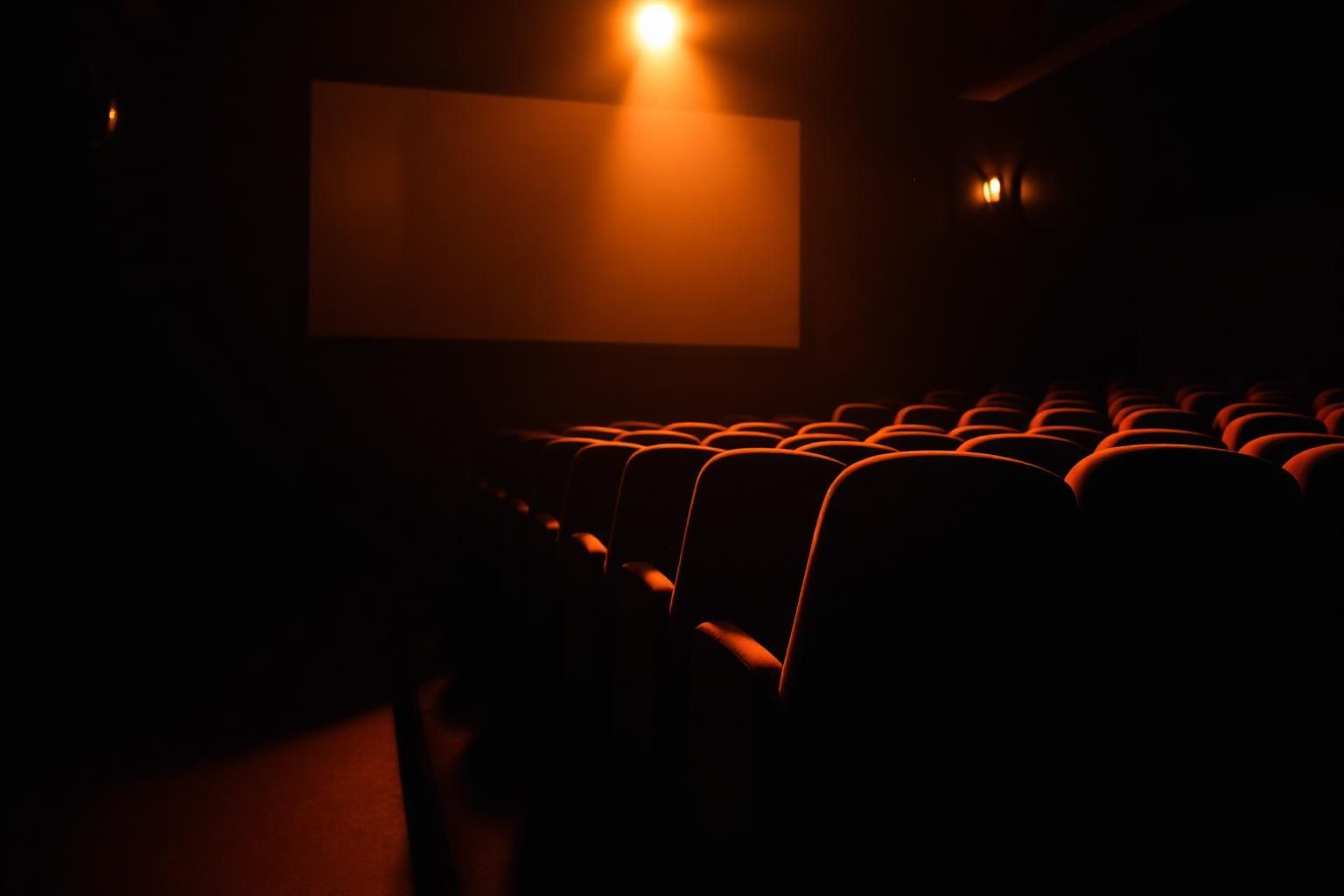Warm intimate cinema interior lit by a single screen
